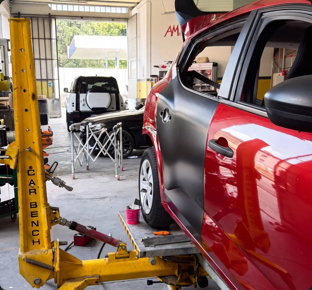 Auto rossa su banco di raddrizzatura per la riparazione di un danno strutturale