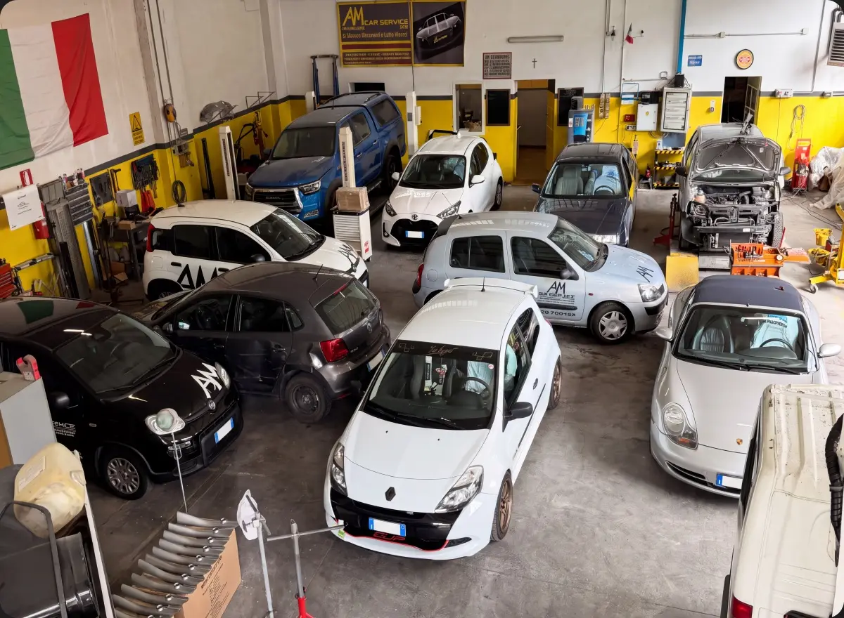 Interno dell'officina AM Car Service con diverse vetture in lavorazione