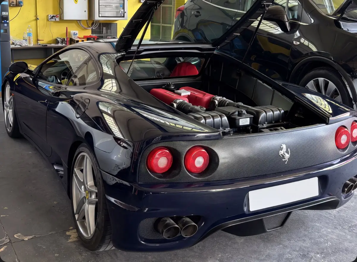 Auto sportiva nera in officina, vista posteriore